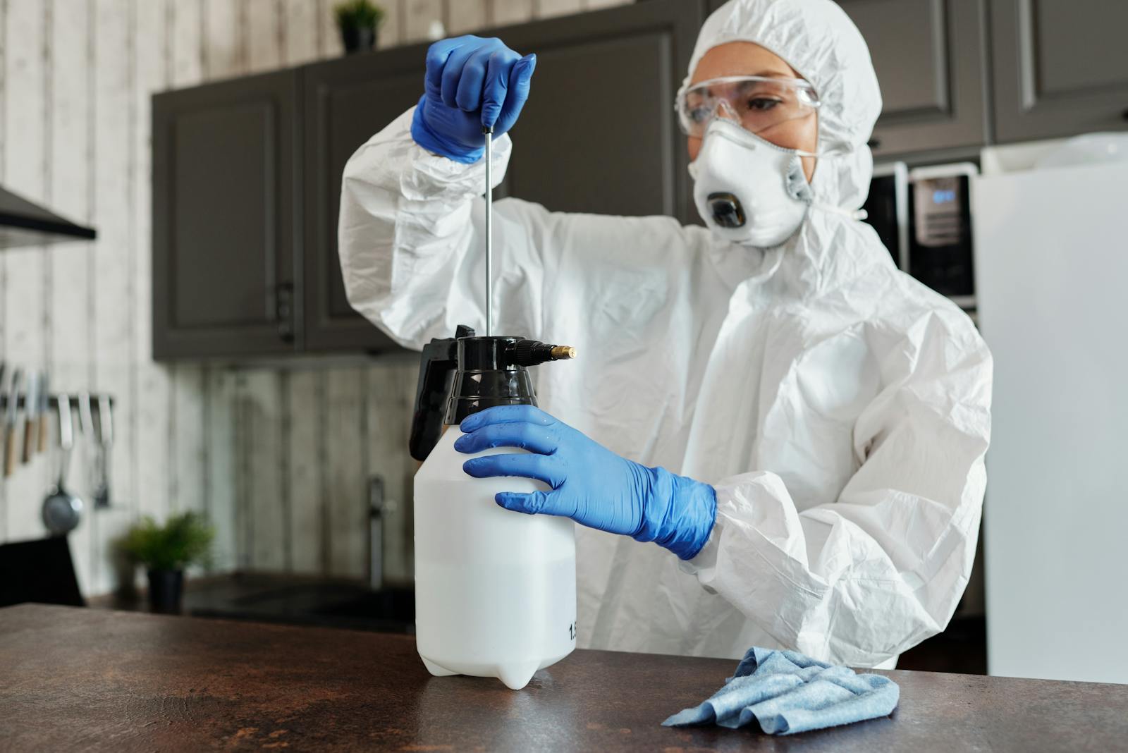 Protective-suit worker disinfecting an interior room